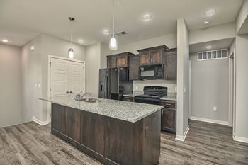 an empty kitchen with a granite counter top and